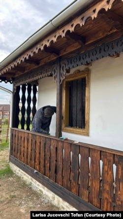 A volunteer works on whitewashing the house on November 11.