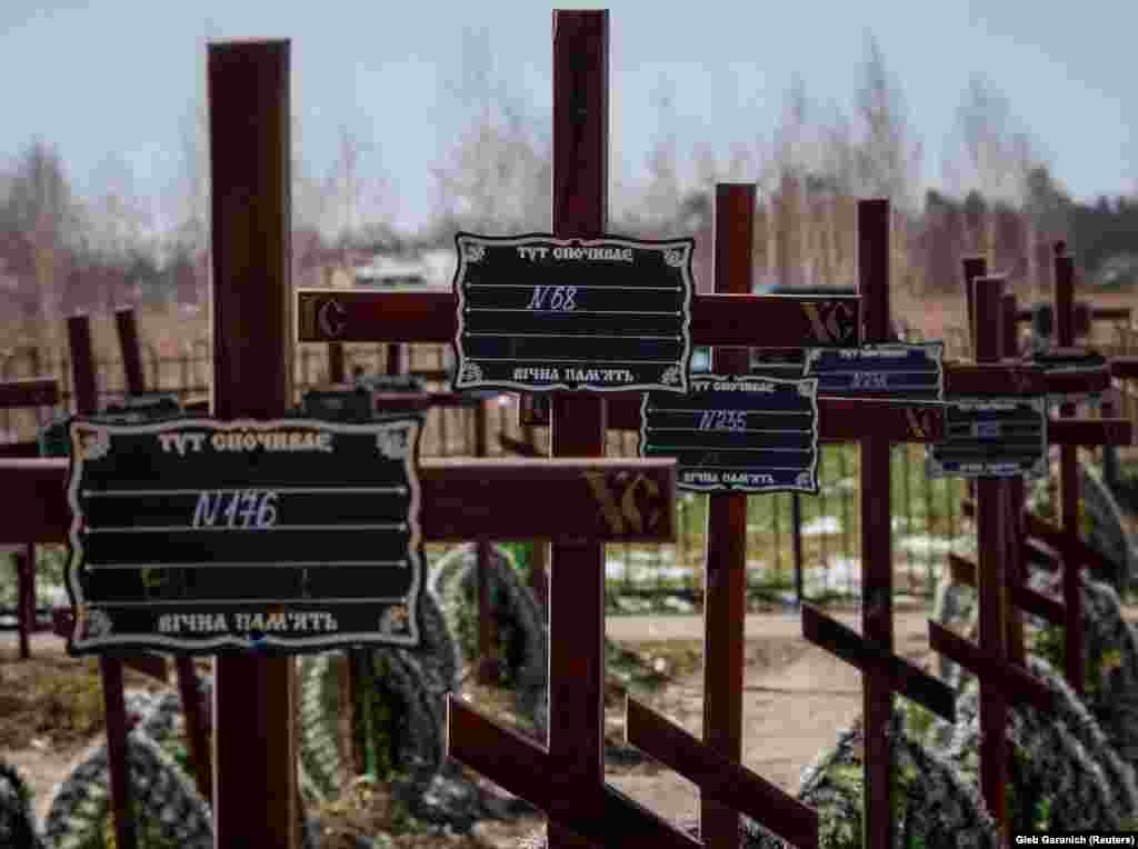 The graves of unidentified people, including children killed during the Russian occupation of Bucha, are marked with numbers.