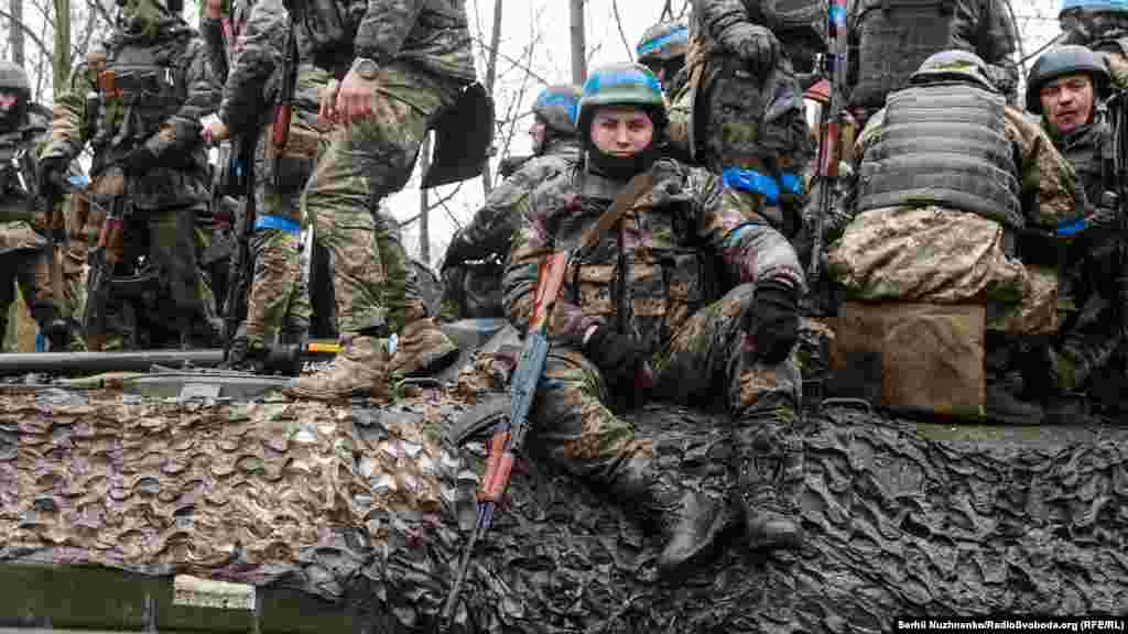 Бійці вантажаться на бронетехніку – БМП та танк – у повній бойовій готовності. Фото від 2 квітня 2022 року
