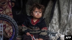 A displaced Palestinian child sitting in a tent at a camp in the city of Rafah, Gaza, in March.