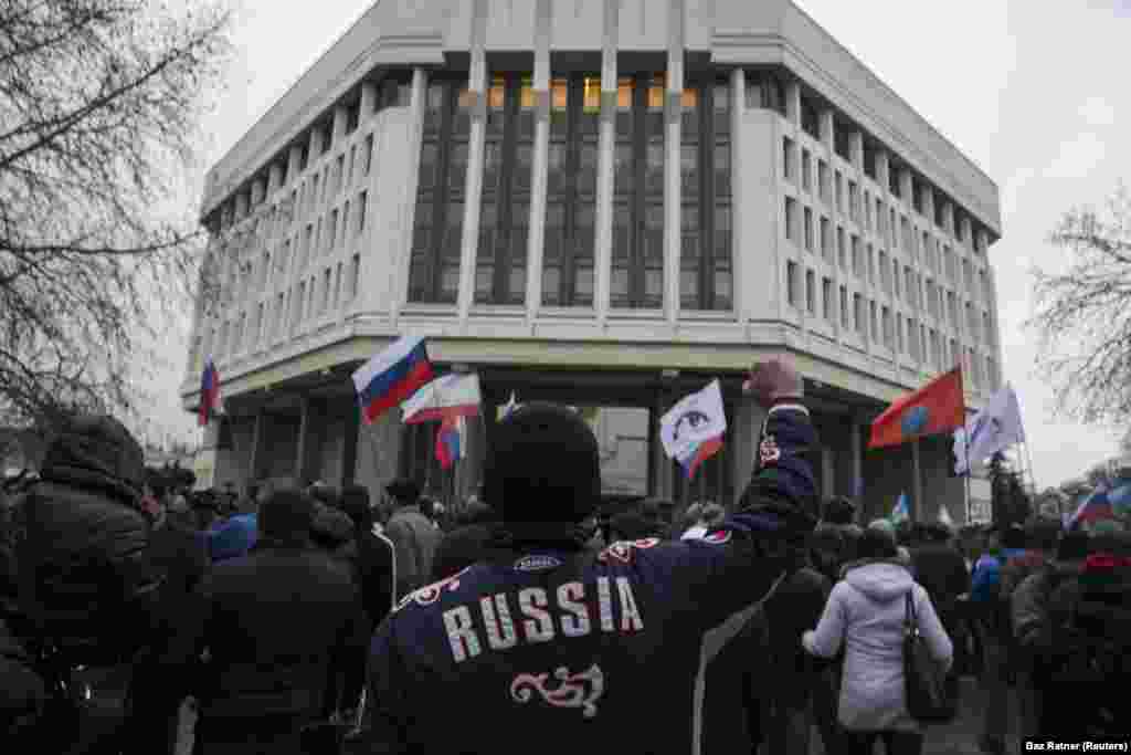 Проросійськи налаштований натовп, як видно з прапорів, біля парламенту Криму, 27 лютого 2014 року. Раніше того ж дня близько 60 проросійських бойовиків захопили будівлю парламенту та кілька блокпостів на Кримському півострові