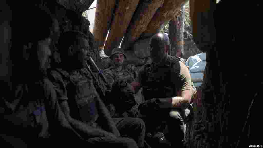 Ukrainian soldiers rest in a trench that was previously held by Moscow's forces. 