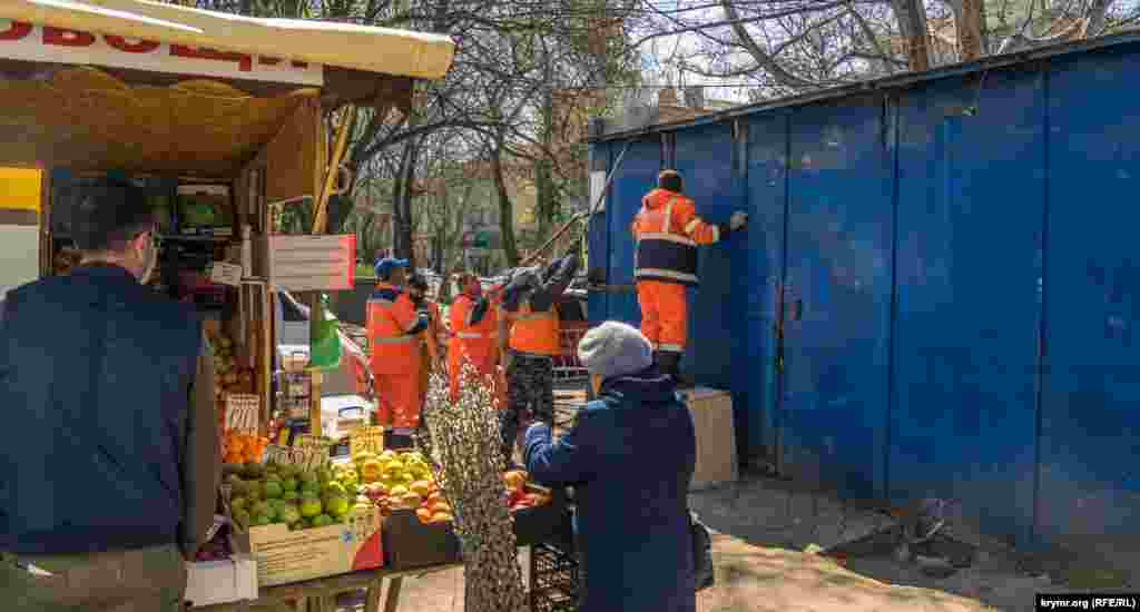 На кіоску з фруктами висить табличка, де тричі написано «Без масок не підходити». Буквально у двох метрах триває демонтаж МАФ-у