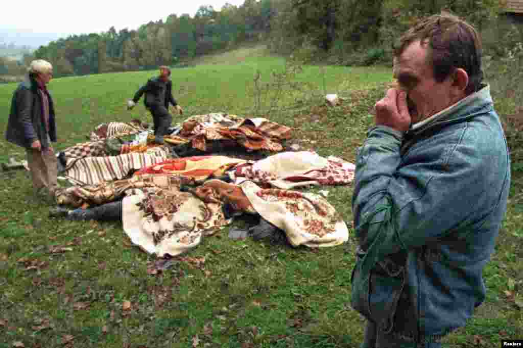 Запах смерті. Етнічний Хорват прикриває ніс під час збирання тіл 15 людей, які залишили гнити на лузі на північному заході Боснії. Численні місця масових поховань були виявлені під час сербського відступу з північно-західної Боснії. 16 жовтня 1995 року