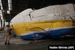 Ангар аеродрому Гостмеля після понад місяця штурмів РФ. Український військовий у звільненому Гостомелі біля уламків літака Мрія