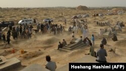 Mourners gather next to graves of victims of the October 8 suicide bomb attack on worshippers at a Shi'ite mosque in Kunduz, in which at least 55 people died. The attack was claimed by the Islamic State-Khorasan.