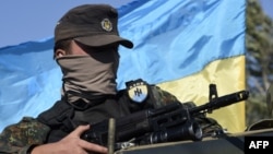 A volunteer for the Ukrainian paramilitary Azov Battalion waits on an armored vehicle, as pro-Russian separatists fire heavy artillery, on the outskirts of Mariupol on September 5.