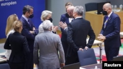 European Commission President Ursula von der Leyen (center) speaks with European Council President Charles Michel (third from right) with other EU leaders during a special meeting of an emergency summit called to discussion Russia's invasion of Ukraine. 