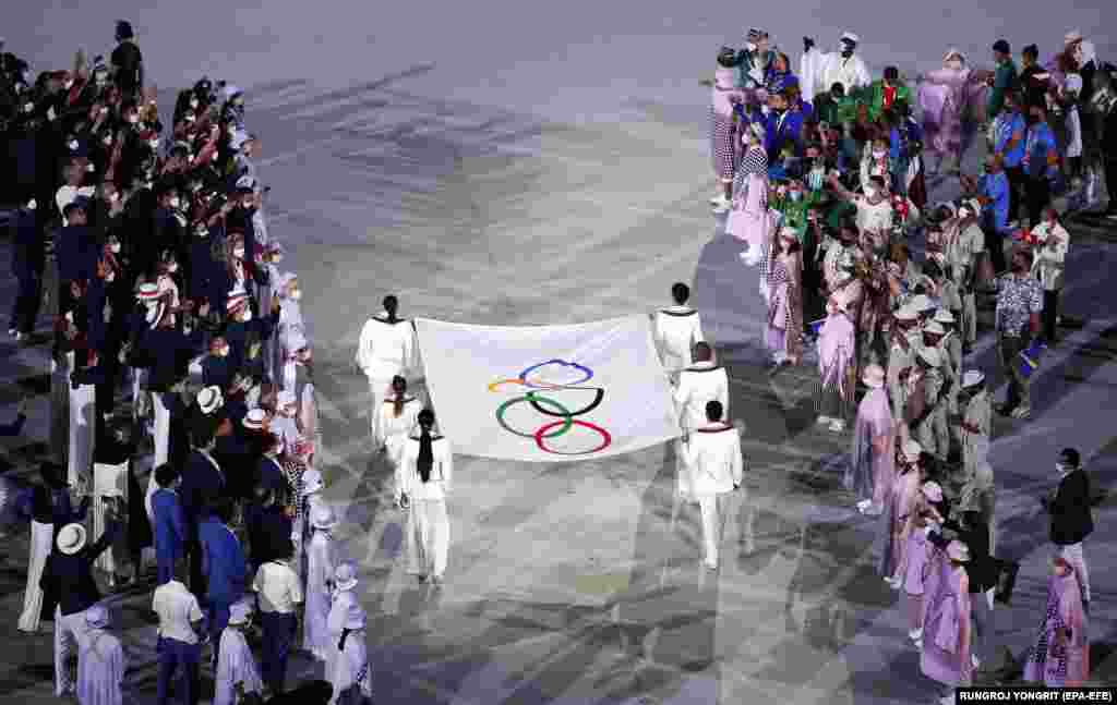 Іноземцям, які не є членами олімпійських делегацій чи журналістами, доступ на Ігри практично закритий. На фото: шість спортсменів несуть Олімпійський прапор на початку церемонії відкриття Олімпіади-2020