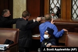 Capitol police, with guns drawn, watch as members of the pro-Trump mob try to break into the House chamber at the U.S. Capitol on January 6.