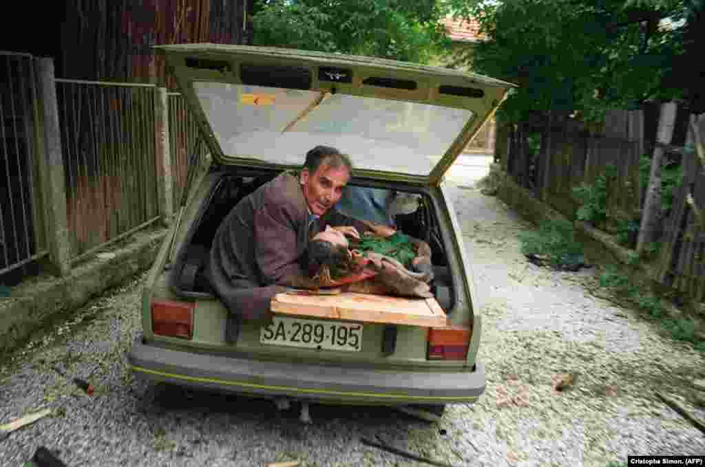 A man cradles the head of a woman badly injured by shelling in Sarajevo on June 27, 1992. 