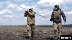 Бійці 68 окремої єгерської бригади імені Олекси Довбуша несуть розвідувальний дрон «Лелека» поблизу Покровська у квітні 2025 року