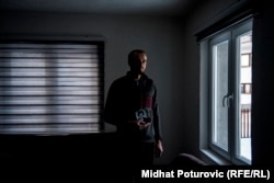 Ahmed Hrustanovic holds photos of his slain family members.