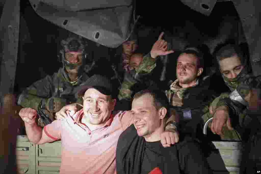 Two men pose for a photo with members of the Wagner mercenary group as they wait in their military vehicle on a street in Rostov-on-Don. The "march for justice" by Prigozhin and his troops was the biggest internal challenge President Vladimir Putin has faced to his rule.