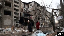 Місцеві жителі йдуть повз зруйнований російським ракетним обстрілом житловий будинок у місті Селидове Донецької області, 16 лютого 2024 року