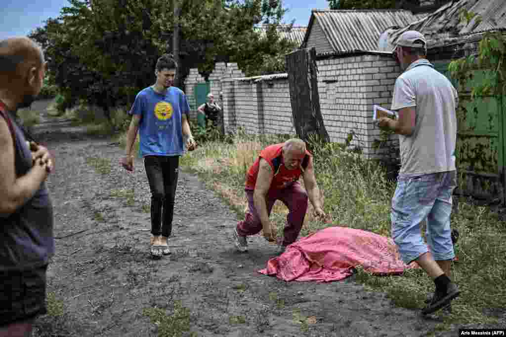 A man rushes to the body of his son who was killed in a reported cluster-bomb attack on Lysychansk, eastern Ukraine, on June 18. 