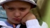 An image shows 6-year-old Damir waiting to be evacuated from his grandfather's house in Dnipropetrovsk region.