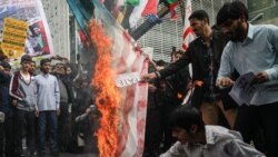 راهپیمایان به نشانه مخالفت با تصویب لوایح پولشویی آن را به صورت نمادین آتش می‌زنند