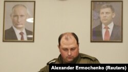 З 2014 року Дмитро Трапезников обіймав керівні посади в угрупованні «ДНР», а після вбивства голови бойовиків Олександра Захарченка був короткий час в.о ватажка «ДНР». На фото Трапезников між портретами Володимира Путіна і Олександра Захарченка. Донецьк, 31 серпня 2018 року