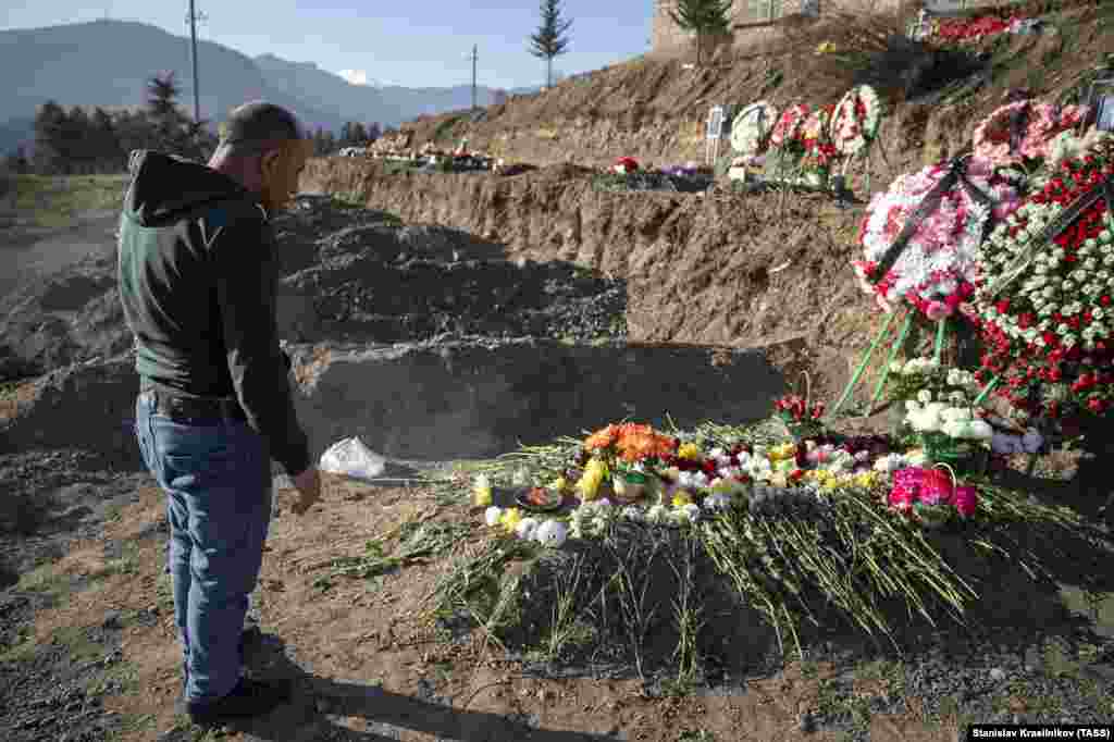 A man stands next to his son's grave in Stepanakert on November 27. The 2020 conflict officially cost the lives of 2,783 Azerbaijani servicemen and 2,425 Armenian soldiers, as has been reported thus far. 