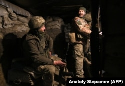 Ukrainian servicemen speak in their dugout on the front line with the separatists not far from Horlivka.