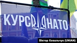 Банер «Курс НАТО» під час світового ланцюга єднання під гаслом #СкажиУкраїніТак / SayYEStoUkraine. Софійська площа в Києві, 22 січня 2022 року