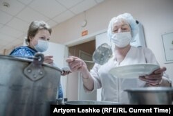 A hospital worker serves a hot meal.