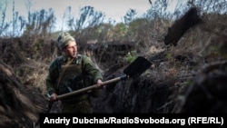 Український військовий копає окоп на запасних позиціях у зоні потенційного розведення військ поблизу Богданівки на Донеччині 