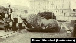 A broken bronze head from a statue of Tsar Alexander III lies discarded on a street in Moscow.