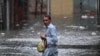 A man wades through a flooded street during heavy monsoon rains in Rawalpindi in Pakistan. 