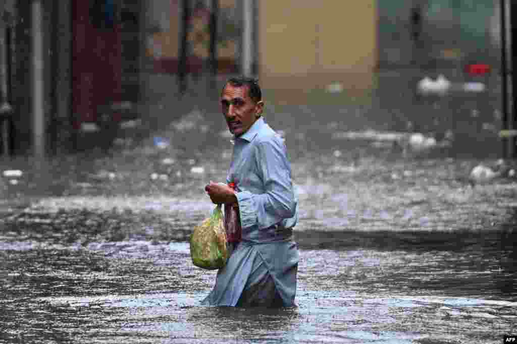 A man wades through a flooded street during heavy monsoon rains in Rawalpindi in Pakistan. 