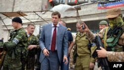 Народный депутат Украины Олег Царев (второй слева) стоит рядом с бойцами вооруженного формирования – батальона «Восток» – возле штаб-квартиры подконтрольной России группировки «ДНР» в Донецке, 12 июня 2014 года