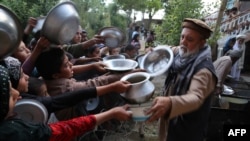 آرشیف، یک مرد افغان در حال توزیع مواد غذایی در ولایت غزنی افغانستان