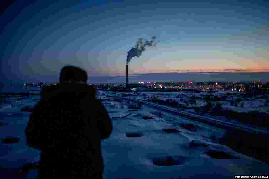 Smoke rises from a chimney over Vorkuta in the evening.