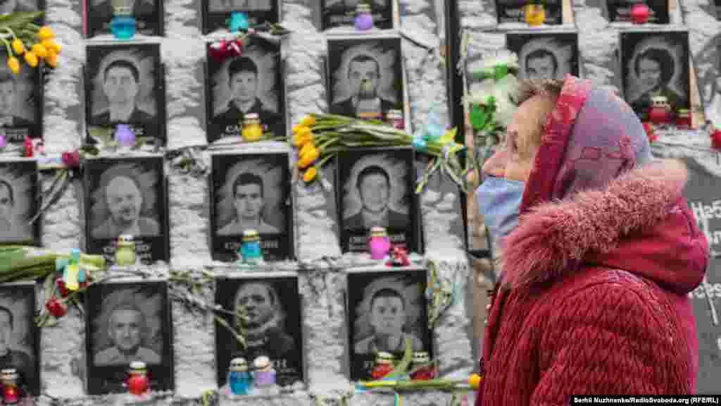 A woman is seen on February 18 in front of the "Heavenly Hundred" monument in Kyiv, honoring the 104 people killed during anti-government demonstrations in 2014.