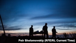 Rescue workers at the MH17 crash site carry away a victim.