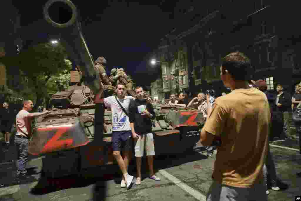Civilians pose for photos as members of the Wagner mercenary group sit atop their tank in Rostov-on-Don. On June 23, the Wagner mercenary group entered Russia from Ukrainian territory in order to seize the Southern Military District's administrative center. Prigozhin claimed that a missile had struck a Wagner camp in Ukraine "from the rear" and charged the Russian military with carrying out the attack. 