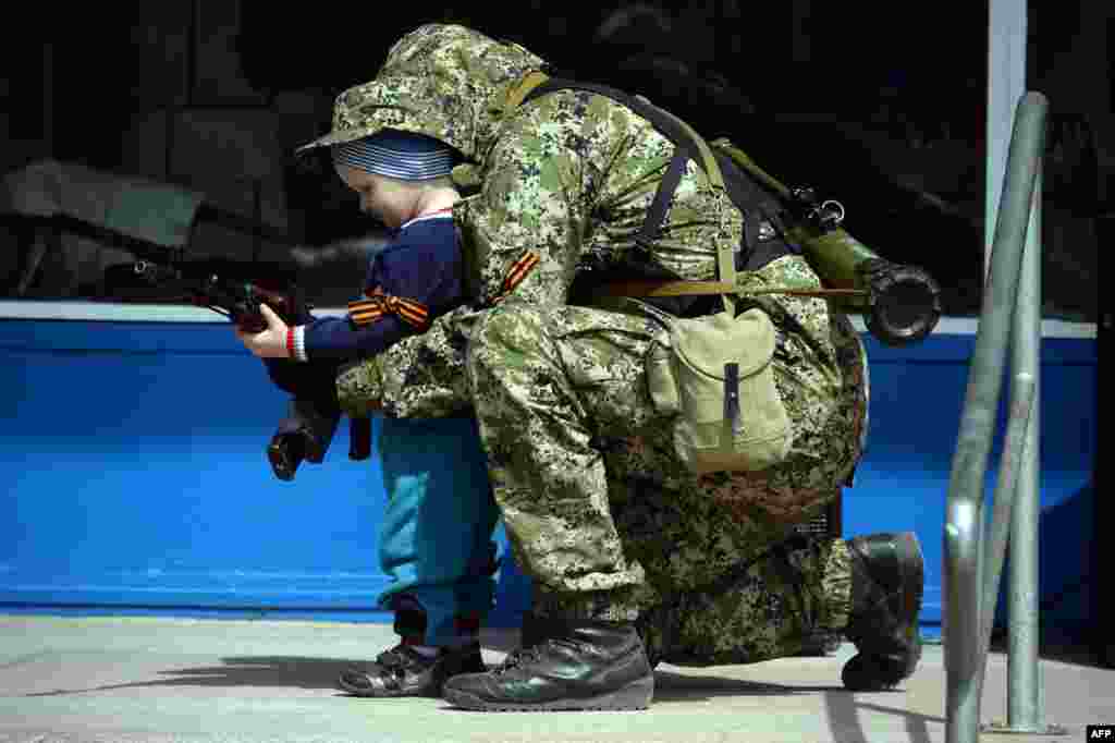 Проросійський бойовик фотографується з дитиною біля захопленої будівлі міліції у місті, Костянтинівка, 28 квітня 2014 року